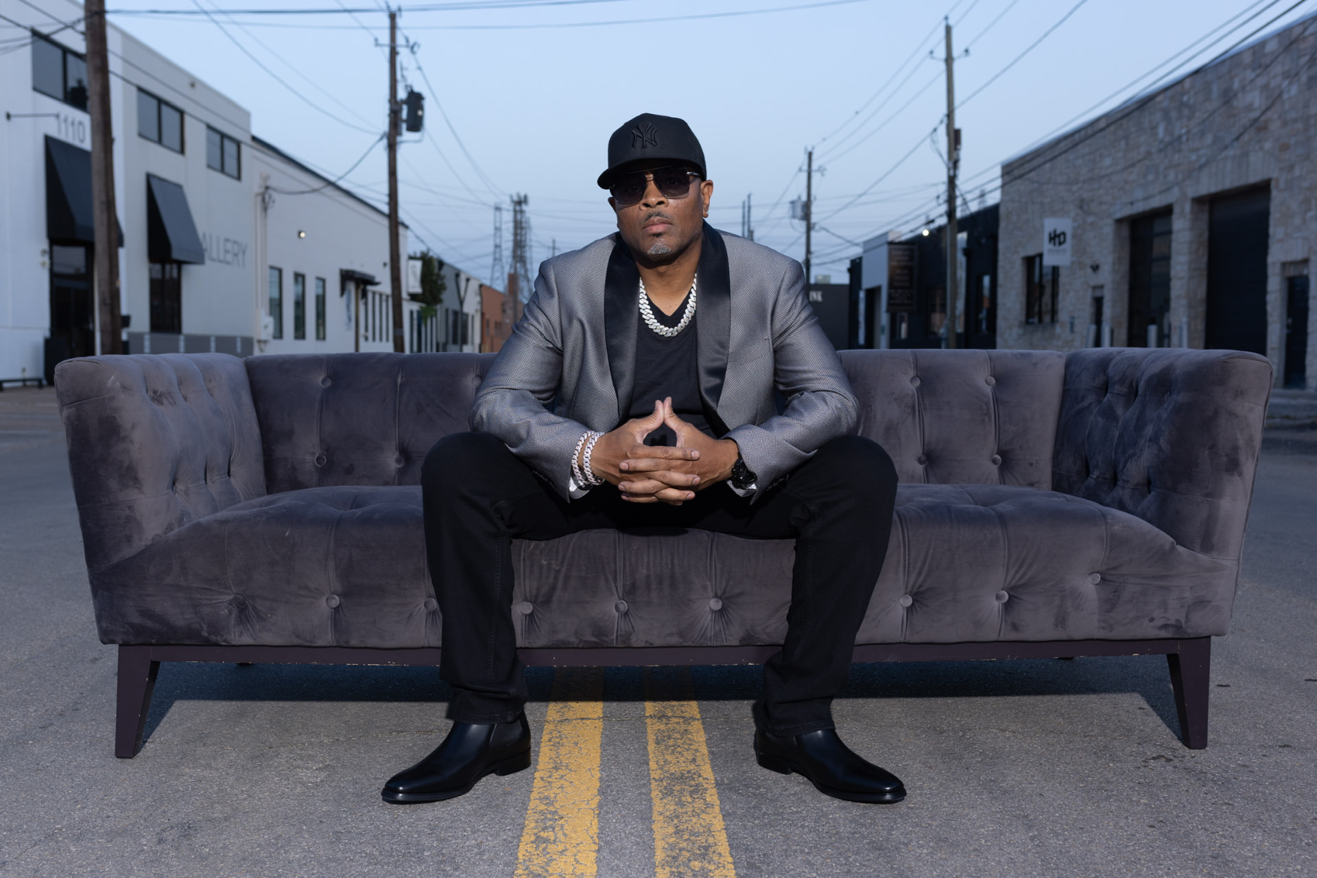Eddie F seated on a velvet couch in the street